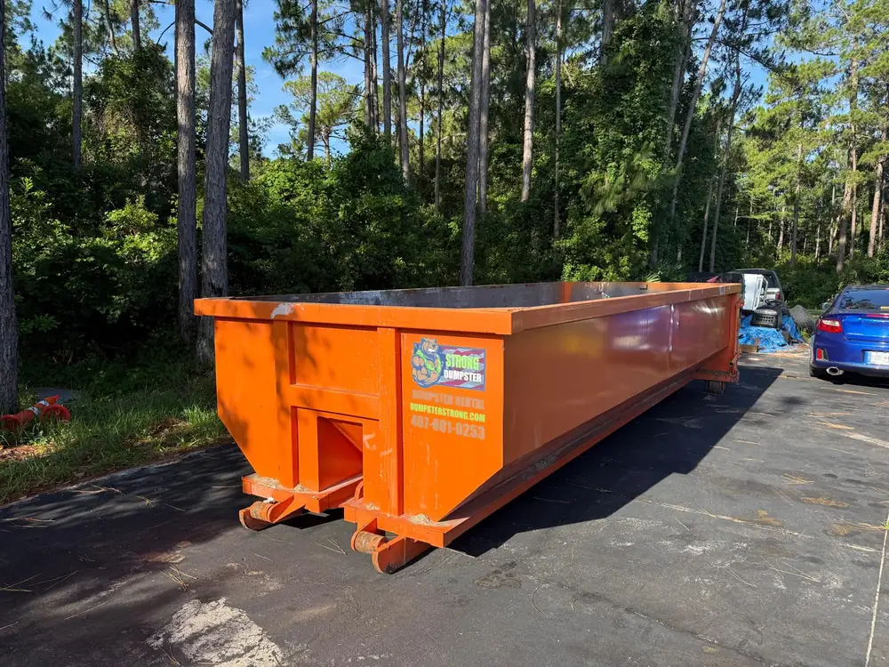 Dumpster Strong 20-yard roll-off dumpster delivered to a wooded St. Cloud FL property near the Lake Nona corridor