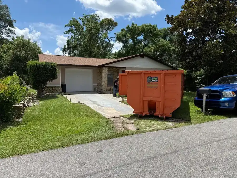 Dumpster on site for a concrete driveway removal and new pour in Orlando