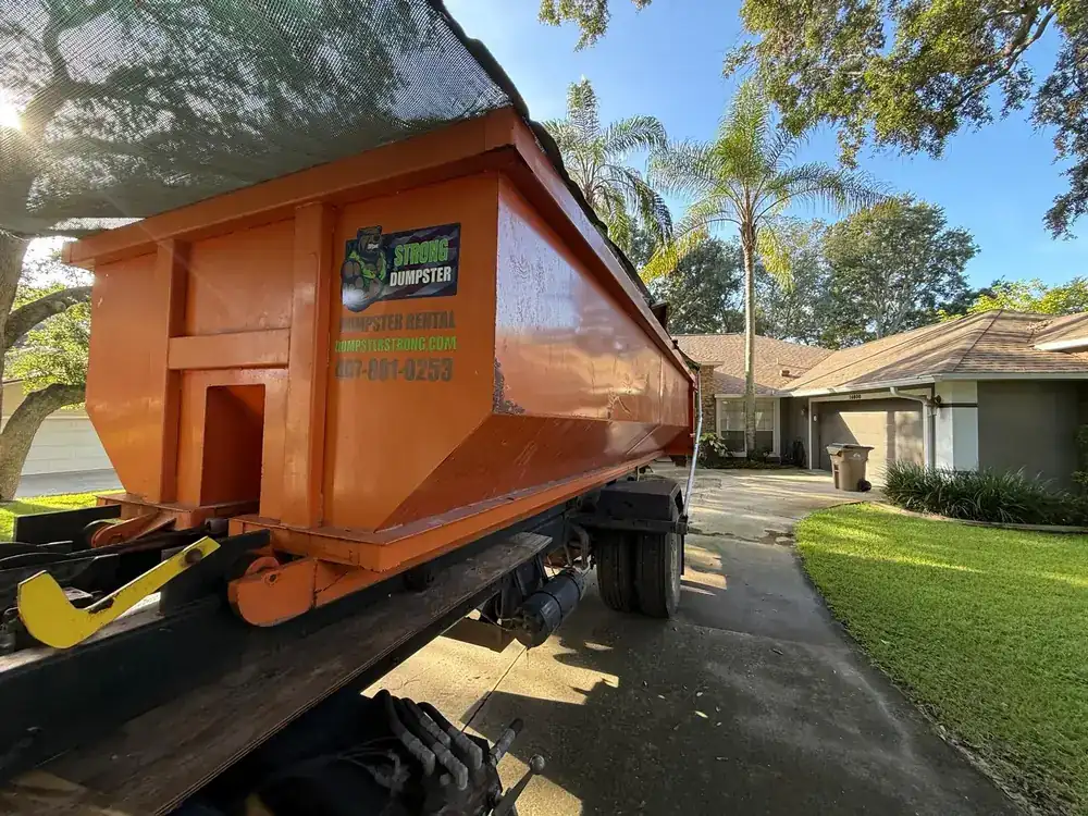 Dumpster Strong roll-off truck delivering a dumpster in Orlando FL