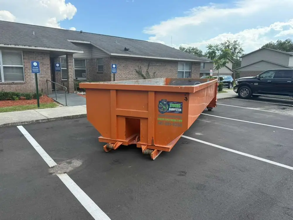 Dumpster Strong roll-off dumpster at an Altamonte Springs FL apartment community parking lot, multifamily property cleanout