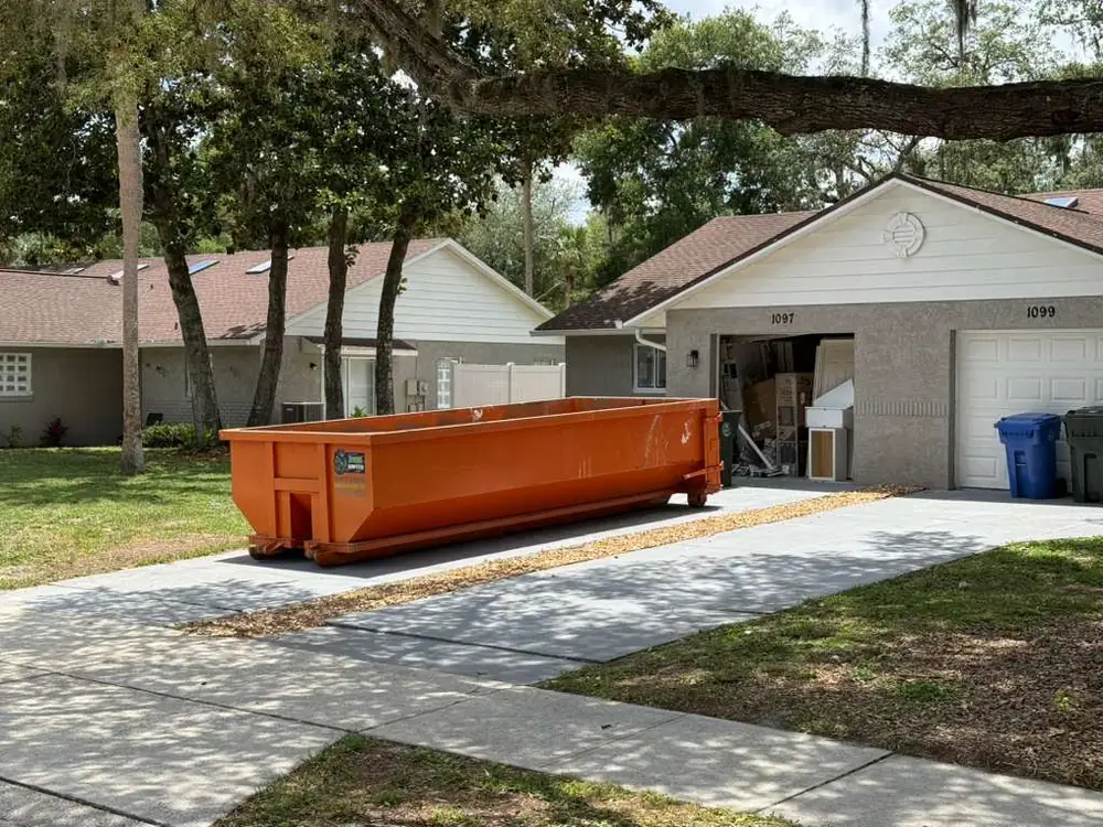 Dumpster Strong roll-off dumpster on a Sanford FL driveway during a garage and home cleanout