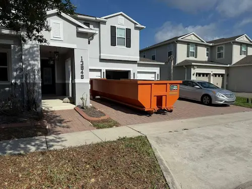 Dumpster Strong 20-yard roll-off dumpster on a modern 2-story home driveway in Windermere FL, delivered curbside