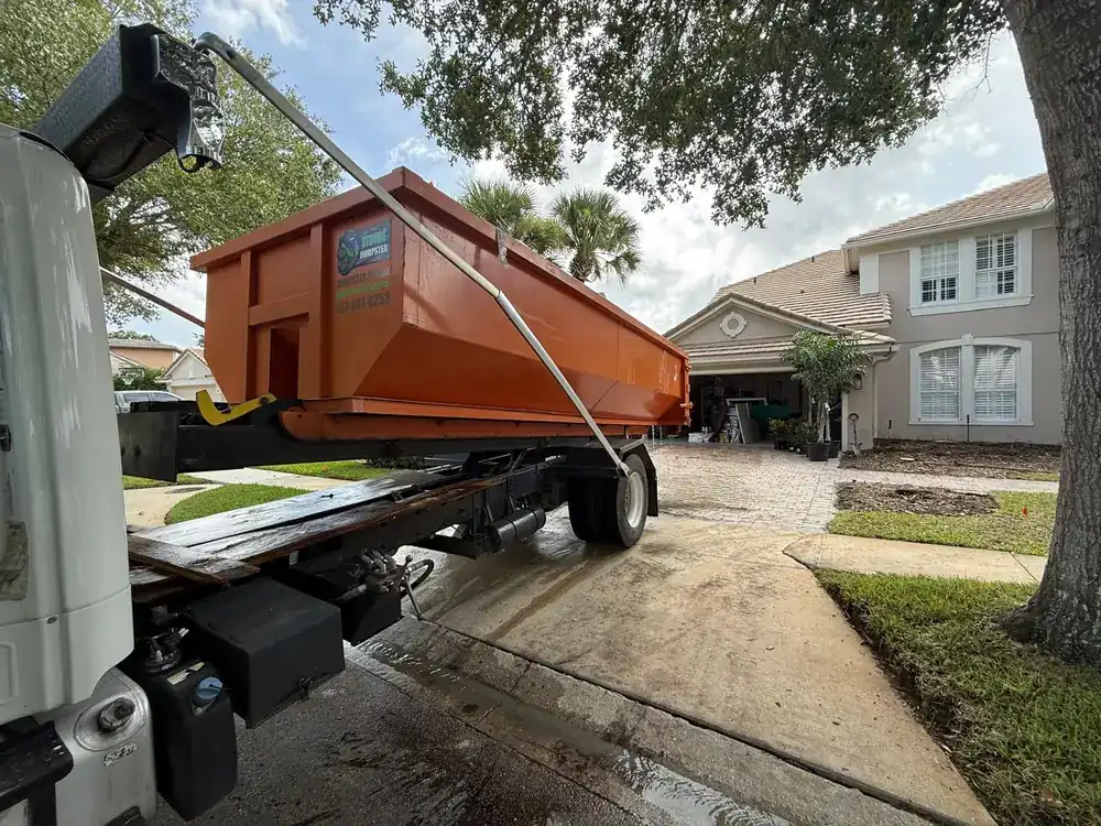 Dumpster Strong roll-off delivered onto a brick paver driveway in Windermere FL with heavy-duty plywood protection boards