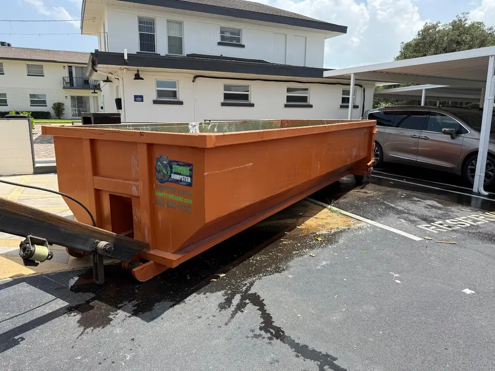 Dumpster Strong roll-off at an apartment complex during a rental unit turnover cleanout, a weekly job type in the Oviedo UCF corridor