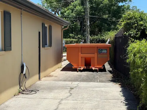 Yard waste dumpster rental from Dumpster Strong at an Oviedo FL home — landscape and tree debris