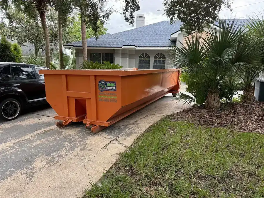 Residential dumpster rental on a palm-lined Dr. Phillips FL driveway
