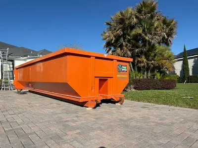 Dumpster Strong orange dumpster on a luxury Windermere FL driveway