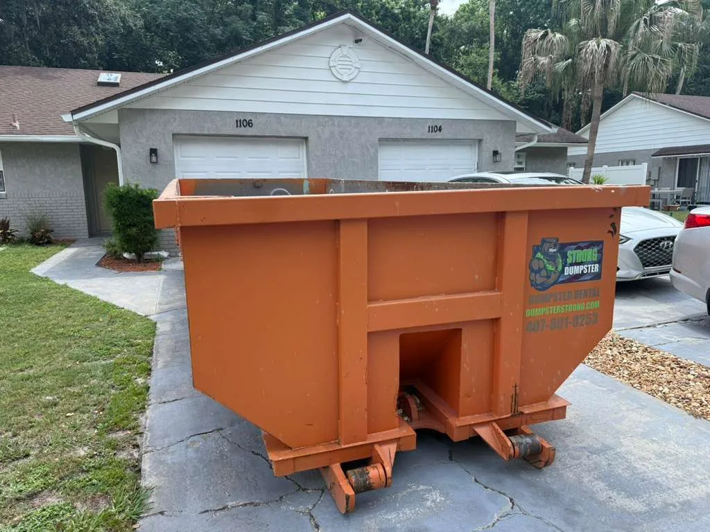 Garage cleanout dumpster on a Winter Park FL home driveway during a weekend declutter